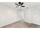 Spacious bedroom featuring wood-look floors, a ceiling fan, closet doors, and an open doorway at 4087 Clock Tower Dr, Port Orange, FL 32129