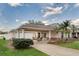 Lovely single-story home featuring a spacious covered drive way, brick detailing, and mature landscaping at 4087 Clock Tower Dr, Port Orange, FL 32129