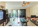 Bright living room boasts tile flooring, sliding glass doors to a balcony and a ceiling fan at 4616 Tower Pine Rd # 4616, Orlando, FL 32839