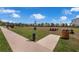 Community playground with picnic tables, play equipment, and open green space at 4827 Lacewing Dr, Winter Garden, FL 34787