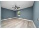 Bedroom with light wood floors, blue walls, ceiling fan, and a window at 5 Redwood Trace Run, Ocala, FL 34472
