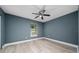 Bedroom featuring sleek floors, blue walls, ceiling fan, and a window at 5 Redwood Trace Run, Ocala, FL 34472
