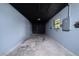 Empty one car garage with light blue walls, a black ceiling, and concrete floor at 5 Redwood Trace Run, Ocala, FL 34472