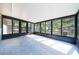 Screened sunroom enclosed with black frames and a light gray concrete floor at 5 Redwood Trace Run, Ocala, FL 34472