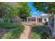 Lush backyard featuring a stone fountain, brick patio, mature landscaping, and classic architecture at 525 Sheridan Blvd, Orlando, FL 32804