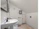 Bright bathroom featuring a pedestal sink, toilet, neutral walls, and a door to storage space at 525 Sheridan Blvd, Orlando, FL 32804