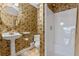 Bathroom featuring wallpaper, pedestal sink, toilet, and shower stall at 525 Sheridan Blvd, Orlando, FL 32804