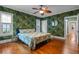 Bedroom with decorative wallpaper, hardwood floors, and natural light from the surrounding windows at 525 Sheridan Blvd, Orlando, FL 32804
