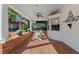 A relaxing covered patio features a ceiling fan, brick flooring, and comfortable white Adirondack chairs at 525 Sheridan Blvd, Orlando, FL 32804