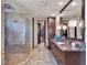 Modern bathroom with a glass shower, marble counters, and dark wood cabinetry at 6137 Grosvenor Shore Dr, Windermere, FL 34786