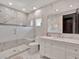 This modern bathroom features white marble and a frameless shower at 6137 Grosvenor Shore Dr, Windermere, FL 34786