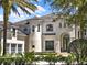 Close up of an elegant two-story home with arched entryway and well-maintained landscaping at 6137 Grosvenor Shore Dr, Windermere, FL 34786