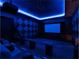 Home theater with tiered seating, projector, and starry night ceiling illuminated with blue light at 6137 Grosvenor Shore Dr, Windermere, FL 34786