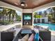 Outdoor living space featuring a fireplace, TV, and ample seating by the pool at 6137 Grosvenor Shore Dr, Windermere, FL 34786