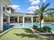 An inviting outdoor pool area with lush landscaping, putting green, and a charming palm tree at 6137 Grosvenor Shore Dr, Windermere, FL 34786