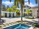 A luxurious pool with a hot tub and a well-manicured patio area with palm trees and seating at 6137 Grosvenor Shore Dr, Windermere, FL 34786