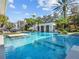 A luxurious pool featuring a swim-up bar and a seating area, surrounded by palm trees and lush landscaping at 6137 Grosvenor Shore Dr, Windermere, FL 34786