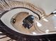 Elegant spiral staircase with a piano display, featuring custom metal railings and natural light at 6137 Grosvenor Shore Dr, Windermere, FL 34786