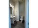 Powder room featuring a pedestal sink and toilet with a wood-look floor at 8243 Fenton St, Orlando, FL 32836
