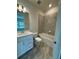 Bright bathroom featuring a tub with gray tiled wall and a vanity with white cabinets and countertop at 8243 Fenton St, Orlando, FL 32836