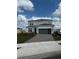 Charming two-story home features a gray exterior, paver driveway, and well-manicured landscaping at 8243 Fenton St, Orlando, FL 32836