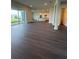 Open floor plan with dark wood floors seamlessly connects living, kitchen, and dining areas at 8243 Fenton St, Orlando, FL 32836