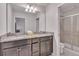 Bathroom features a double sink granite countertop and shower with glass door at 8840 Bengal Ct, Kissimmee, FL 34747
