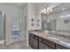 Bathroom with granite countertop vanity, double sinks, and a glass-enclosed shower at 8840 Bengal Ct, Kissimmee, FL 34747