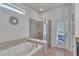 Bright bathroom showcasing a soaking tub, glass-enclosed shower, and access to an outdoor patio at 8840 Bengal Ct, Kissimmee, FL 34747
