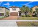 Two-story home boasts a lush, landscaped front yard and a brick-paved driveway leading to a two-car garage at 8840 Bengal Ct, Kissimmee, FL 34747