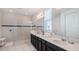 Elegant bathroom with dual sinks, glass-enclosed shower, and modern fixtures at 9004 Sunshine Ridge Loop, Kissimmee, FL 34747