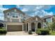 Charming home featuring a stone archway, two-car garage, and neatly landscaped yard at 9004 Sunshine Ridge Loop, Kissimmee, FL 34747