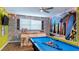 Fun game room with a brick accent wall, surfboard decor, and a blue pool table at 9004 Sunshine Ridge Loop, Kissimmee, FL 34747