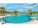 Resort style pool with palm trees and lounge chairs for relaxing by the water at 9004 Sunshine Ridge Loop, Kissimmee, FL 34747