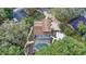 Aerial view of a home featuring a screened-in pool, lush landscaping, and surrounding neighborhood at 1204 Swan St, Winter Springs, FL 32708