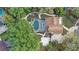 Aerial view of a home featuring a screened-in pool, lush landscaping, and winding walkways at 1204 Swan St, Winter Springs, FL 32708
