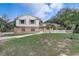 Charming two-story home with brick accents, a well-manicured lawn, and mature palm trees at 1204 Swan St, Winter Springs, FL 32708