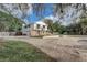 Angle view showcasing the home's spacious driveway and manicured front yard, surrounded by trees at 1204 Swan St, Winter Springs, FL 32708