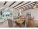 Elegant dining room with exposed wood beams, seating for six, and serene water views from the adjacent living area at 3168 S Peninsula Dr, Daytona Beach, FL 32118