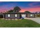 Charming single-story home with well-manicured lawn and inviting entrance, enhanced by colorful sunset backdrop at 5828 Westport Dr, Port Orange, FL 32127