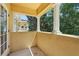 Outdoor covered balcony with yellow walls and white columns, offering a private retreat at 8639 Lower Villagewalk Cir, Orlando, FL 32827