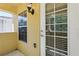 Side view of a balcony featuring yellow stucco walls and a white door at 8639 Lower Villagewalk Cir, Orlando, FL 32827