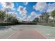 Full view of outdoor basketball court surrounded by tall hedges and a chain link fence at 8639 Lower Villagewalk Cir, Orlando, FL 32827