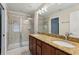 Bathroom with double sinks, granite countertop, and glass-enclosed shower for a spa-like experience at 8639 Lower Villagewalk Cir, Orlando, FL 32827