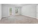 Spacious bedroom featuring carpeted floors, crown molding, and a door leading to a private balcony at 8639 Lower Villagewalk Cir, Orlando, FL 32827