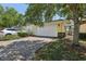 Paver driveway leading to a two-car garage with mature landscaping at 8639 Lower Villagewalk Cir, Orlando, FL 32827