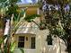 Two-story home with neutral colors, a balcony, and lush tropical landscaping in front at 8639 Lower Villagewalk Cir, Orlando, FL 32827