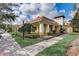 Beautiful yellow exterior with white columns, terracotta roof, and manicured landscaping at 8639 Lower Villagewalk Cir, Orlando, FL 32827