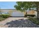 Exterior view of the garage with a brick driveway and trimmed bushes at 8639 Lower Villagewalk Cir, Orlando, FL 32827