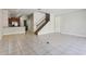 Open-concept living area with tile floors, staircase, and access to the kitchen at 8639 Lower Villagewalk Cir, Orlando, FL 32827